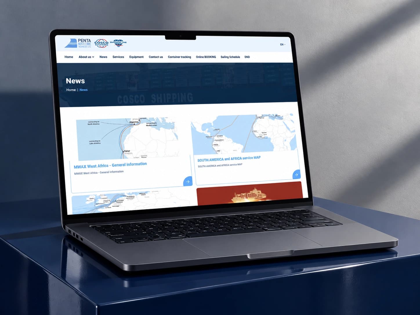 The penta.lv news section on a laptop on a dark blue plinth.