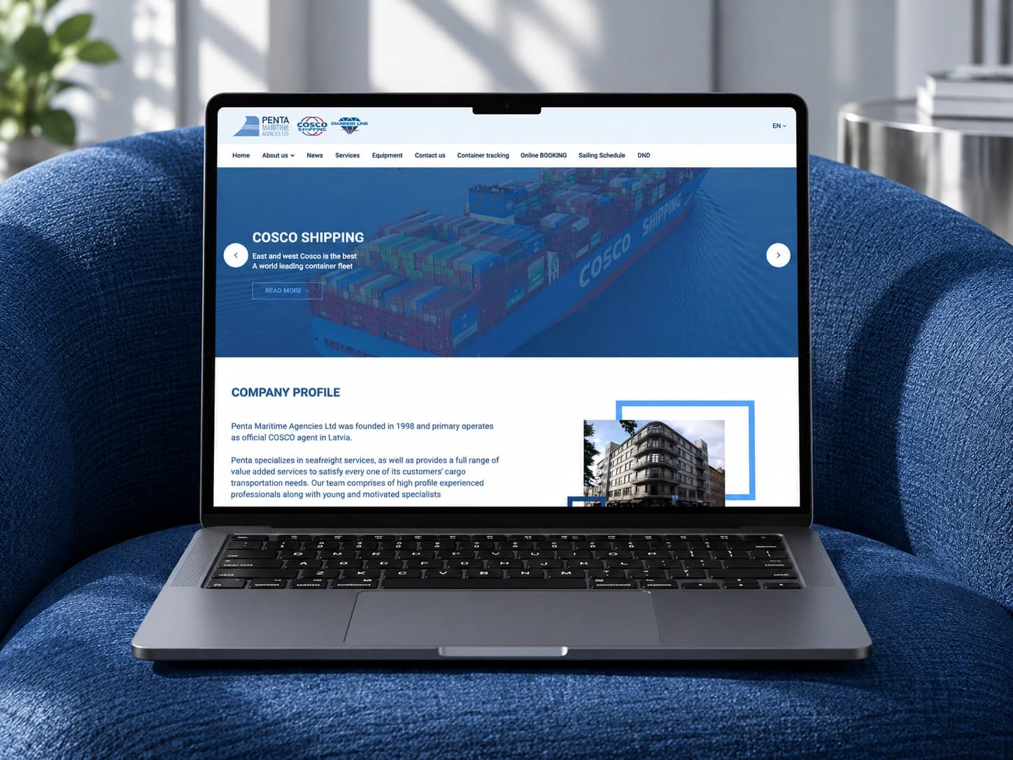 The penta.lv homepage on a laptop in a blue armchair.