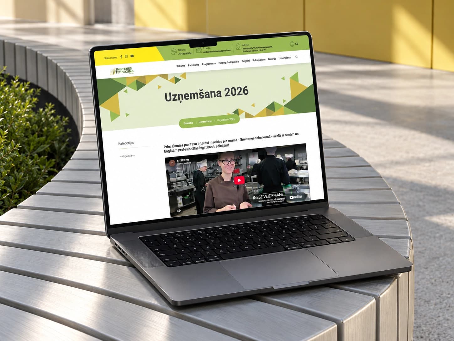 The Smiltenes tehnikums admissions page on a laptop on a silver bench.