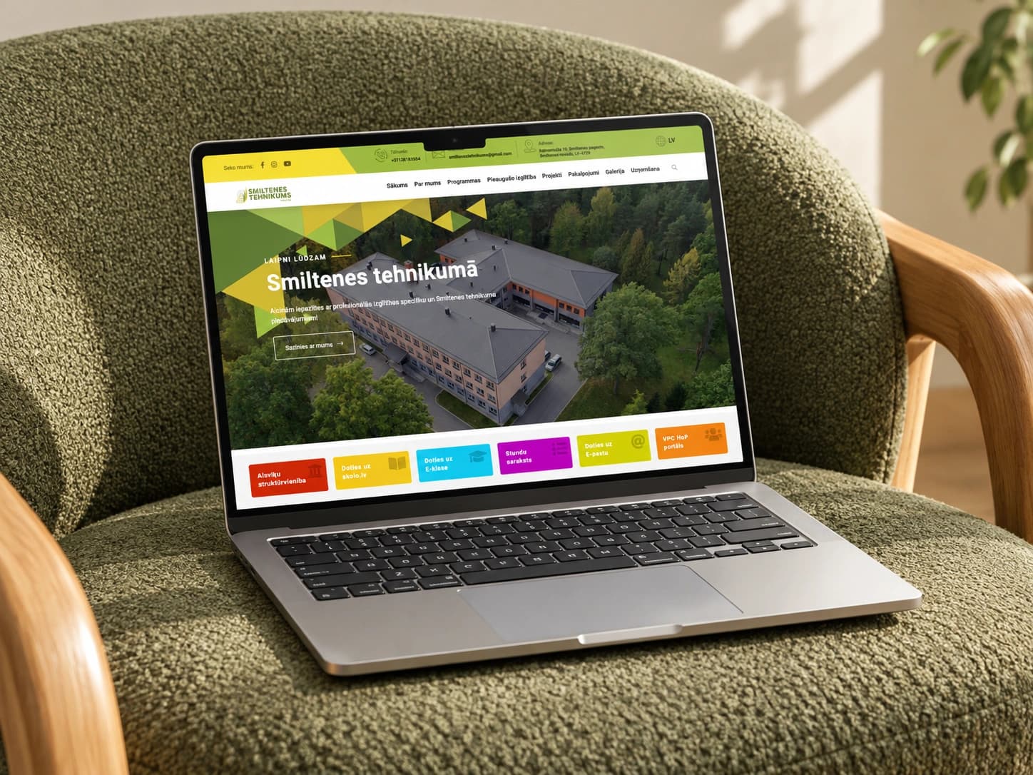The Smiltenes tehnikums homepage on a laptop in an olive armchair.